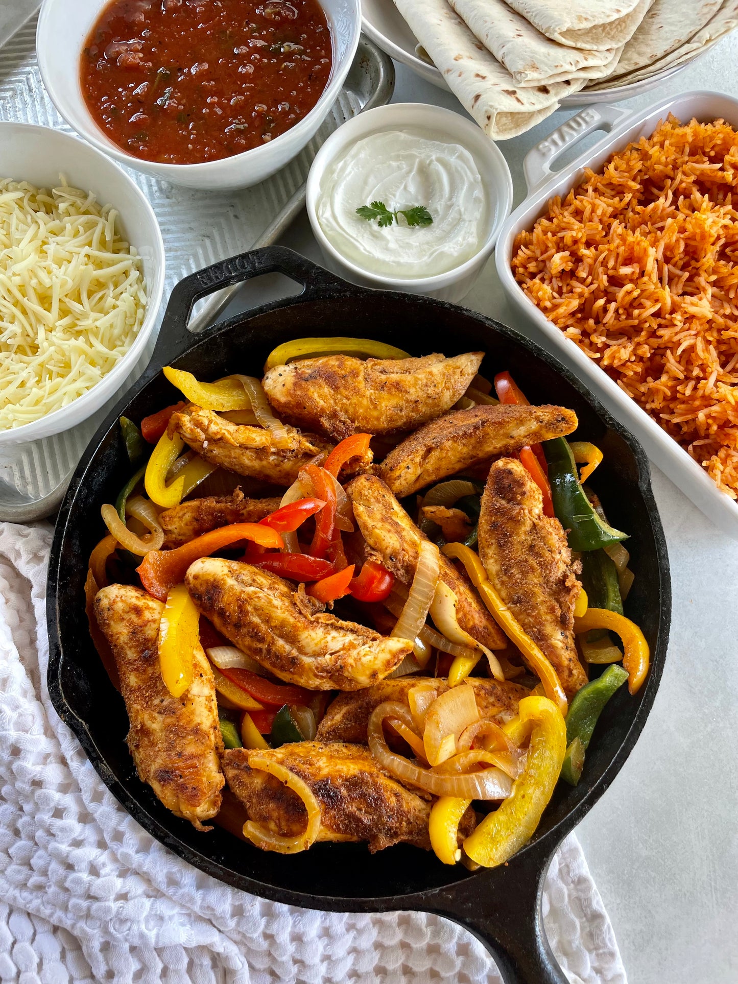 Chicken Fajitas served with Spanish Rice, Flour Tortillas, Handmade Salsa, cheese, and sour cream.